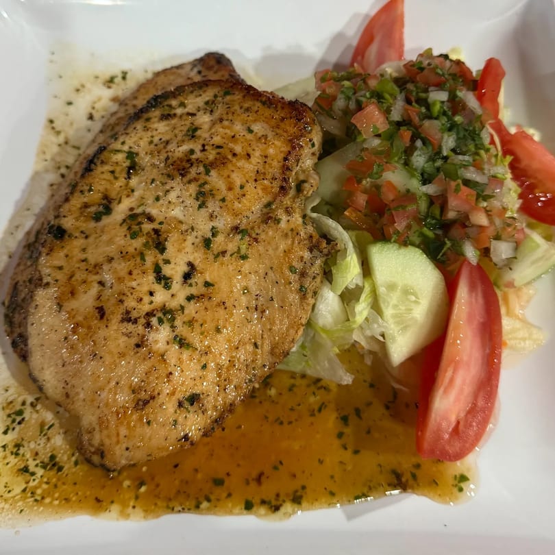 Angiolina's grilled chicken breast with a side salad of lettuce, cucumbers, tomatoes, and pico de gallo.